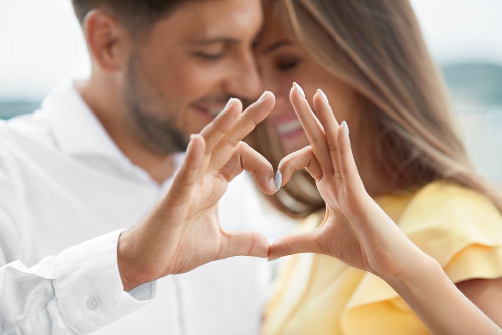 Sugar dating couple making heart with hands