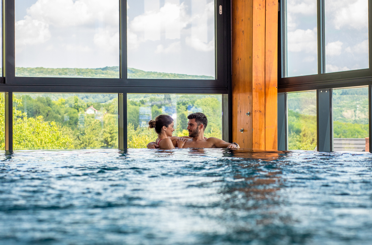 Ein Paar verbringt Zeit miteinander und entspannt sich im Hallenbad einer Adults-Only-Hotelanlage.