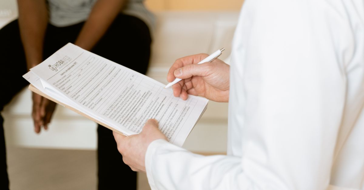 Medizinische Fachkraft bespricht in einer Klinik einen Befund mit einer Patientin.